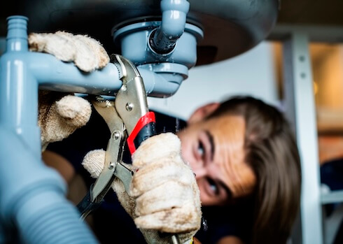 Drain and Plumbing Services Plumber Fixing Kitchen Sink