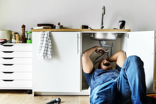 Plumber man fixing kitchen sink Installing Kitchen Sink Drain