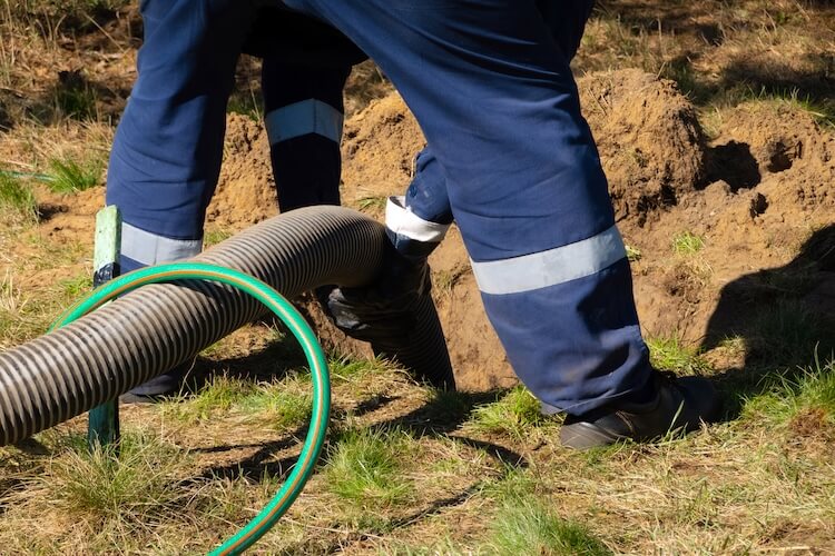 man-worker-holding-pipe-providing-sewer-cleaning-service Sewer Line Cleaning Service